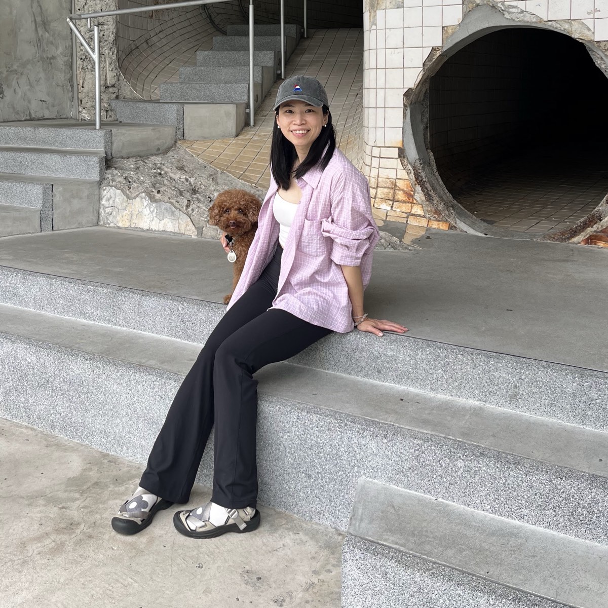 Spring sitting on concrete steps with a small brown dog
