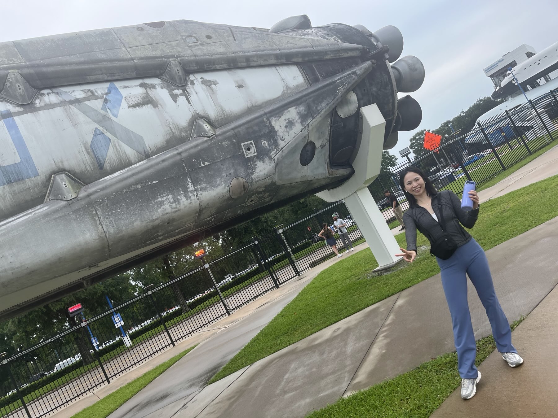 Spring standing next to a Falcon 9 rocket stage on display